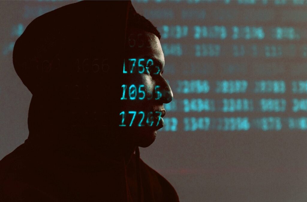 man standing in the dark with ominous numbers shining on his face